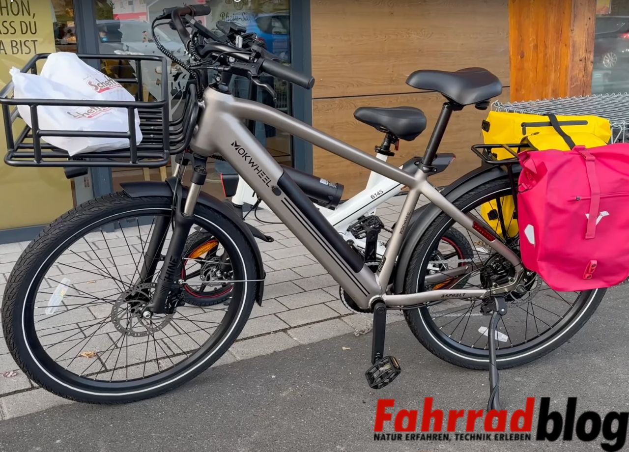 Mokwheel Asphalt E-Bike vor dem Supermarkt mit Fahrradtaschen